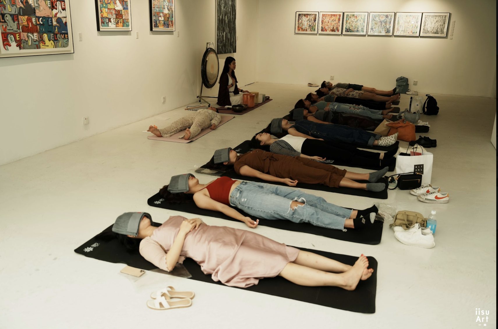 Guests resting during a sound bath in an art gallery
