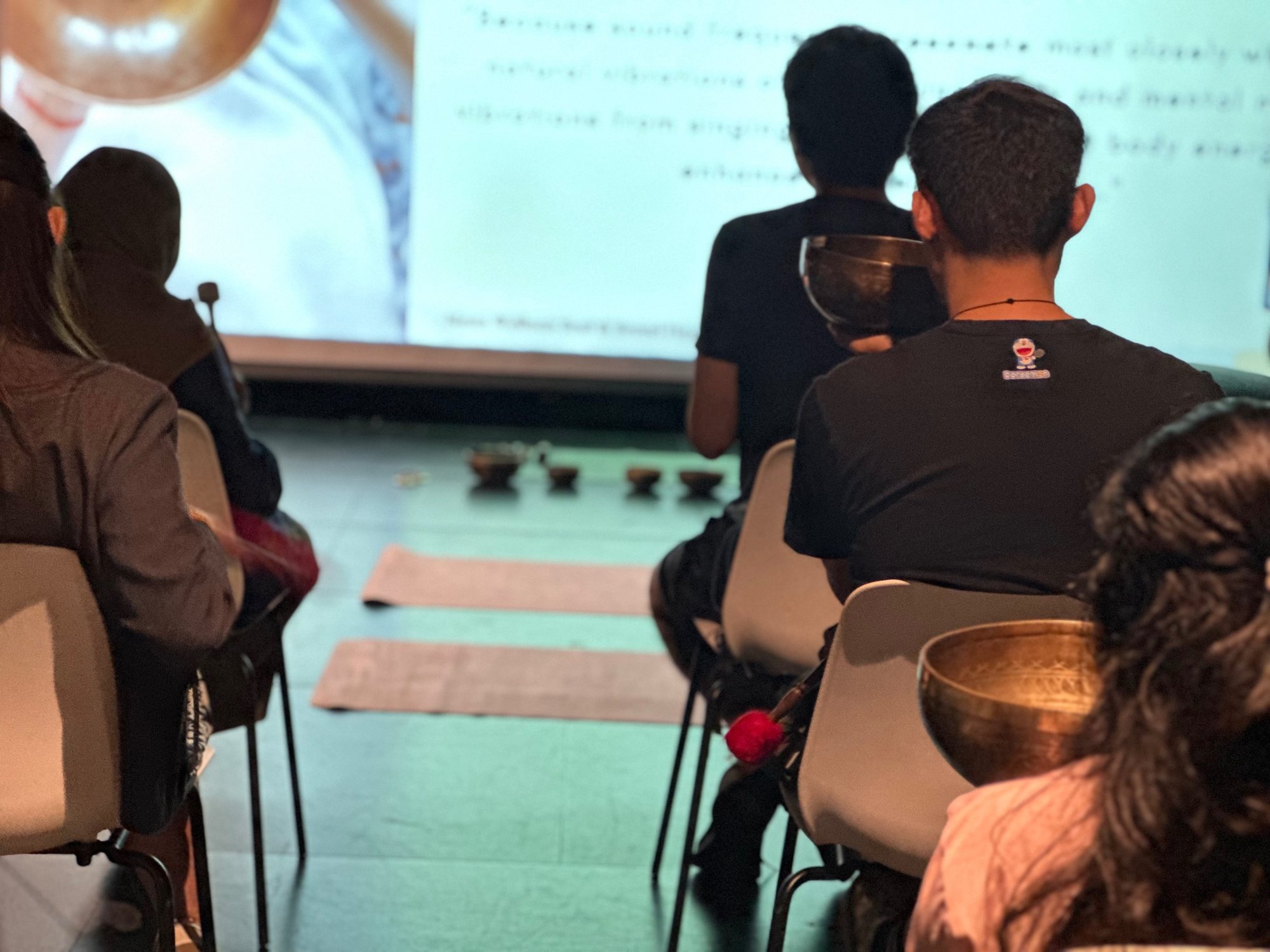 A student holding a singing bowl during a university workshop