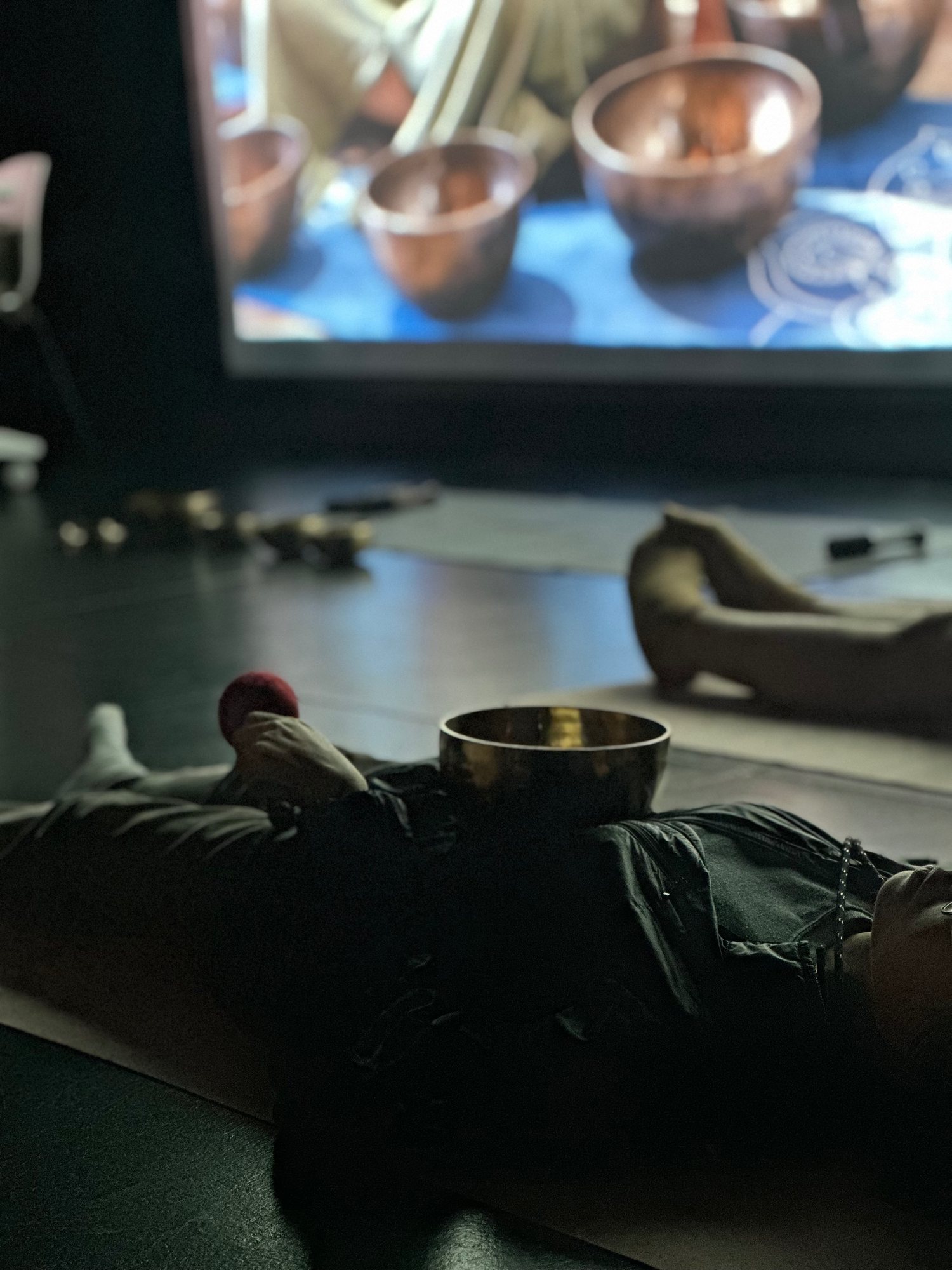 A singing bowl resting on a student during sound practice